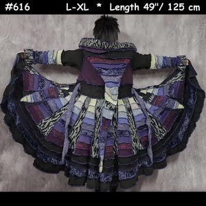 May include: A long-sleeved coat with a hood, labelled #616, size L-XL, and 125 cm in length. The garment features a patchwork design in shades of purple, black, and white, with layered, ruffled fabric panels and a flared, circular hemline.