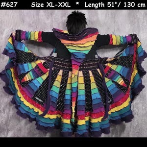 May include: A multi-coloured hooded coat featuring a patchwork design of ribbed knit fabric in shades of purple, blue, green, yellow, and red, with black textured panels. The garment is labelled #627, size XL-XXL, and has a length of 130 cm.