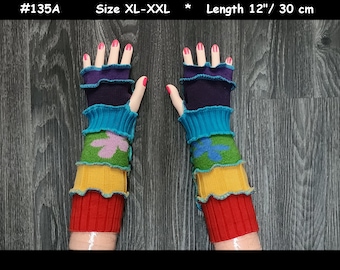 May include: A pair of colorful, layered fingerless gloves. The gloves are approximately 12 inches long and feature a vibrant array of colors including red, yellow, green, blue, and purple. Each layer has a ruffled edge, and the green layer has a floral design.