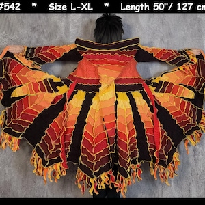 May include: A long, flowing, crocheted cardigan with a layered, flame-like design in shades of black, red, orange, and yellow. The cardigan has a hood and is approximately 50 inches long.