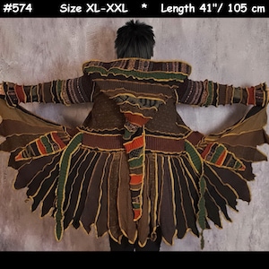 May include: A long, brown, multi-colored, knitted cardigan with a hood. The cardigan has a fringed hem and is made of recycled materials. #574 Size XL-XXL * Length 41" / 105 cm