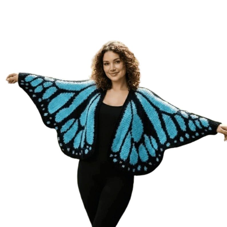 May include: A blue and black butterfly wing-shaped cardigan. The open-front sweater features a knitted design with blue wings outlined in black. The cardigan is worn over a black top and pants.