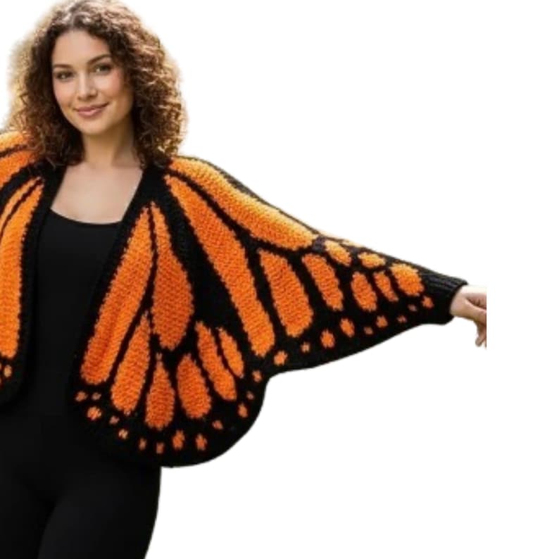 May include: A knitted butterfly wing-shaped cardigan in orange and black. The cardigan features a detailed pattern mimicking the veins and markings of a monarch butterfly's wings. The garment is designed to be worn over the shoulders.