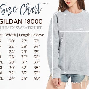 Może przedstawiać: Tabela rozmiar&oacute;w szarej bluzy Gildan 18000 z wymiarami w calach dla rozmiar&oacute;w od S do 5XL. Tabela zawiera szerokość, długość i długość rękawa, wraz z diagramem pokazującym, w jaki spos&oacute;b należy dokonywać pomiar&oacute;w odzieży w celu dopasowania.