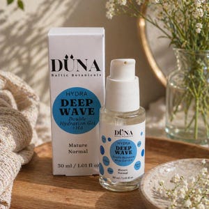 Pode incluir: Uma apresentação de produto para cuidados com a pele com uma caixa branca e um frasco transparente com uma bomba. A caixa e o frasco têm o texto "DÜNA Baltic Botanicals" e "HYDRA DEEP WAVE Double Hydration Gel + HA". O frasco contém 30 ml de produto.