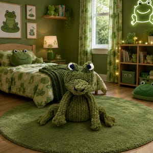 May include: A large, textured, olive green plush frog toy sits on a matching round rug in a bedroom. The room features frog-themed bedding, a green lamp, a neon frog sign on the wall, and shelves filled with various small frog-shaped plush items.