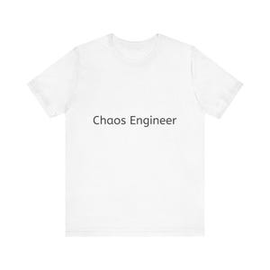 May include: White t-shirt with the text "Chaos Engineer" printed in black. The shirt is a short-sleeved crew neck style, suitable for casual wear. The text is centered on the front of the shirt.