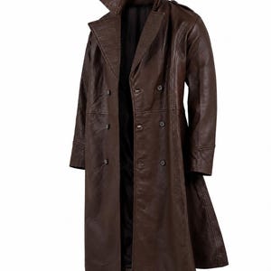 May include: A dark brown, double-breasted leather trench coat featuring a wide notched collar, long sleeves, and a series of dark buttons down the front. The coat has a structured silhouette with a smooth finish and a black interior lining.
