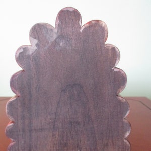 Op de afbeelding: Een decoratieve houten doos, rood en bruin, met gegolfde rand.