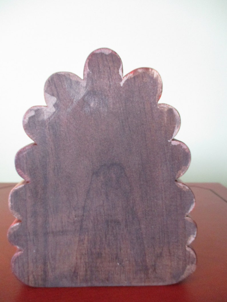 Op de afbeelding: Een decoratieve houten doos, rood en bruin, met gegolfde rand.