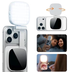 May include: A white portable LED ring light attachment for a smartphone, featuring a foldable hinge, a square light panel, and a circular mirror on the back. The device mounts onto the rear of a phone, providing illumination for photography.