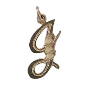 May include: A gold-colored pendant in the shape of the letter "J" in a cursive script. The pendant has a textured outline and a lighter, possibly gem-filled, interior. It includes a small loop for attaching to a chain.