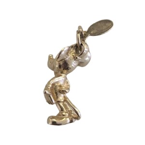 Pode incluir: Um pingente dourado em forma de personagem de desenho animado, em p&eacute; com um pequeno la&ccedil;o na parte superior para fixa&ccedil;&atilde;o. O pingente &eacute; detalhado com as caracter&iacute;sticas do personagem, incluindo orelhas, rosto e roupas. O pingente &eacute; provavelmente feito de metal.
