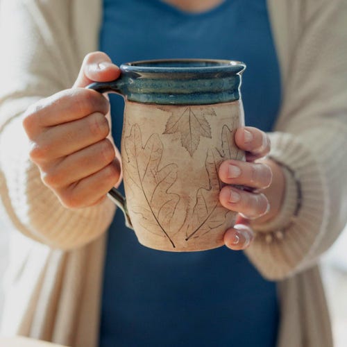 Mug artisanal en céramique bleue de 47 cl (16 oz) avec motif de feuilles naturelles, idéal pour les amateurs de café. Décoration rustique inspirée par la nature.