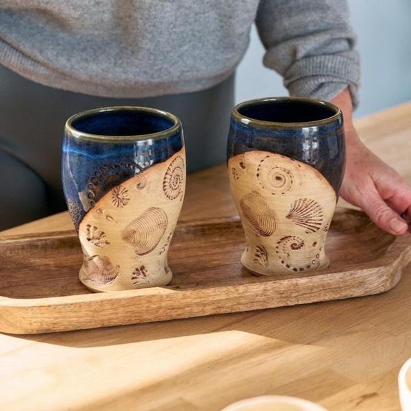 Handgemaakte blauwe aardewerk beker met schelpimpressies cadeau idee strandliefhebber rustiek kust keukengerei oceaan thema artisinaal servies