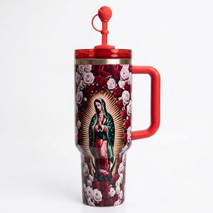 May include: A red and burgundy tumbler featuring an image of Our Lady of Guadalupe surrounded by roses. The tumbler has a red handle, a red lid, and a red straw with a rose-shaped top. The design includes red and white roses.