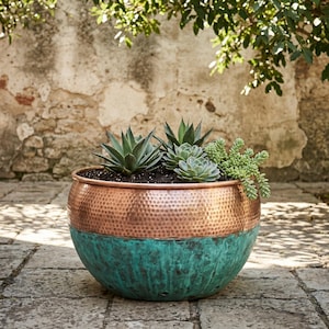 Peut inclure: Un pot de fleurs rond en forme de bol avec une partie supérieure en cuivre martelé et une partie inférieure à la patine vert sarcelle vieillie. Le pot est rempli de terreau sombre et de diverses plantes succulentes, dont des agaves et des sédums.