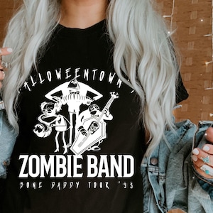May include: Black t-shirt with a white graphic of a band of zombies. The text "Halloweentown Zombie Band" is above the graphic, and "Done Daddy Tour '93" is below. The shirt is a crew neck.