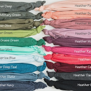 May include: A collection of folded fabric samples in various colors, including heather deep, military green, olive, green, grass green, mint, ice blue, deep teal, slate, and navy. Each sample is labeled with its color name.
