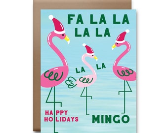 May include: A Christmas card featuring three pink flamingos wearing Santa hats. The flamingos are standing in a blue pool of water with the text "Fa La La La La" and "Happy Holidays Mingo" on the card.