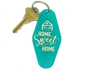 May include: Teal blue motel key chain with a white house graphic and the text "Home Sweet Home".