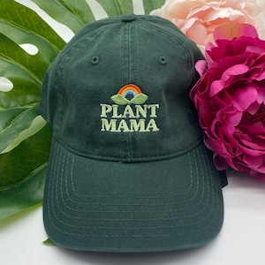 May include: A dark green baseball cap with an embroidered rainbow and the text "PLANT MAMA" in white.