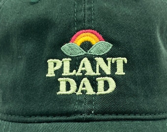 May include: A dark green baseball cap with an embroidered rainbow and the text "PLANT DAD" in yellow.
