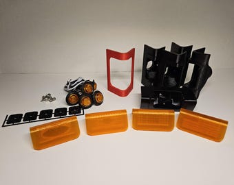Puede incluir: Un surtido de componentes de iluminación automotriz, que incluye lentes ámbar, soportes de montaje negros, un marco rojo y un juego de luces ámbar pequeñas. También se incluyen tornillos y cableado.