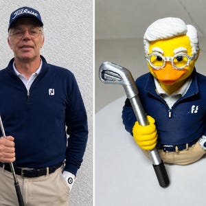 Puede incluir: Una figura de pato de goma amarillo estilizada como un golfista, con un jersey azul marino de cremallera con un logotipo blanco, pantalones beige y gafas de montura blanca. El pato sostiene un palo de golf de color plateado en su ala derecha.
