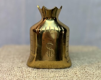 Pisapapeles promocional de latón con forma de bolsa de dinero de mantequilla de cacahuete Skippy vintage