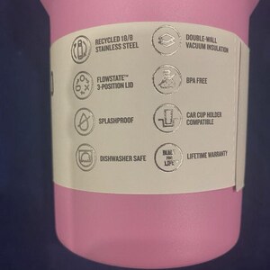 May include: A pink insulated tumbler with a white label. The label includes text that reads "RECYCLED 18/8 STAINLESS STEEL", "FLOWSTATE 3-POSITION LID", "SPLASHPROOF", "DISHWASHER SAFE", "DOUBLE-WALL VACUUM INSULATION", "BPA FREE", "CAR CUP HOLDER COMPATIBLE", and "LIFETIME WARRANTY".