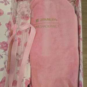 Pu&ograve; includere: Un set regalo rosa Stanley Love Shack Fancy in una scatola floreale. Il set include un articolo in peluche rosa, una bottiglia trasparente e nastri rosa. La scatola ha un motivo a rose.