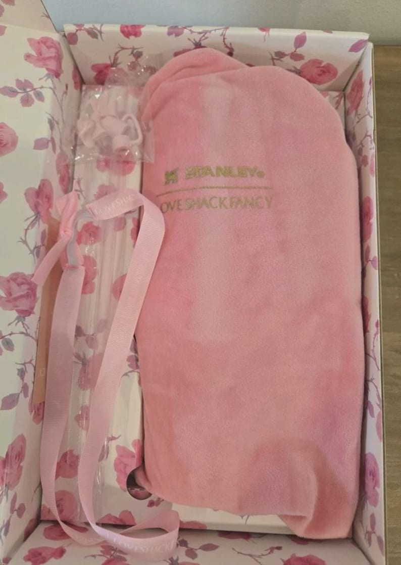 Pu&ograve; includere: Un set regalo rosa Stanley Love Shack Fancy in una scatola floreale. Il set include un articolo in peluche rosa, una bottiglia trasparente e nastri rosa. La scatola ha un motivo a rose.