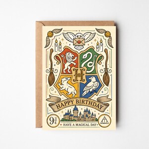 May include: A cream-coloured greeting card featuring a central crest with a lion, snake, badger, and eagle, surrounded by illustrations of an owl, brooms, and candles. The text reads "HAPPY BIRTHDAY" and "HAVE A MAGICAL DAY" with a castle graphic.