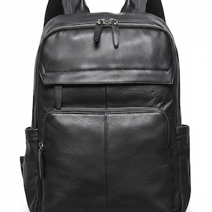 Puede incluir: Una mochila de cuero negro con superficie texturizada, asa superior, dos correas ajustables para los hombros, un compartimento principal grande con cierre de doble cremallera, un bolsillo frontal con cremallera y dos bolsillos laterales.