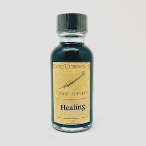 May include: A clear glass bottle filled with dark blue liquid, topped with a black screw cap. The label features the text Ceridwen's Scribe Supplies Healing, a feather illustration, and the volume 1 fl oz external use only.