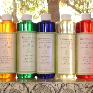 May include: Five clear plastic bottles of Geridwen's Bubble Bath & Shower Gel, each containing 232 ml of liquid in orange, green, blue, clear, and red. Each bottle features a white cap and a label with a triquetra symbol and text.