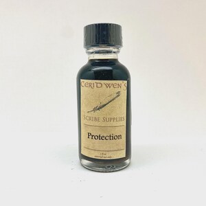 May include: A small clear glass bottle filled with dark liquid, featuring a black screw-top cap and a tan rectangular label. The label displays the text Ceridwen's Scribe Supplies, Protection, and 1 fl oz external use only, along with a feather illustration.