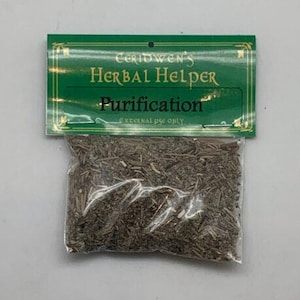 May include: A clear plastic pouch containing a mixture of dried brown and grey herbs. The pouch is attached to a green cardboard header card with gold text that reads Ceridwen's Herbal Helper, Purification, and External Use Only.