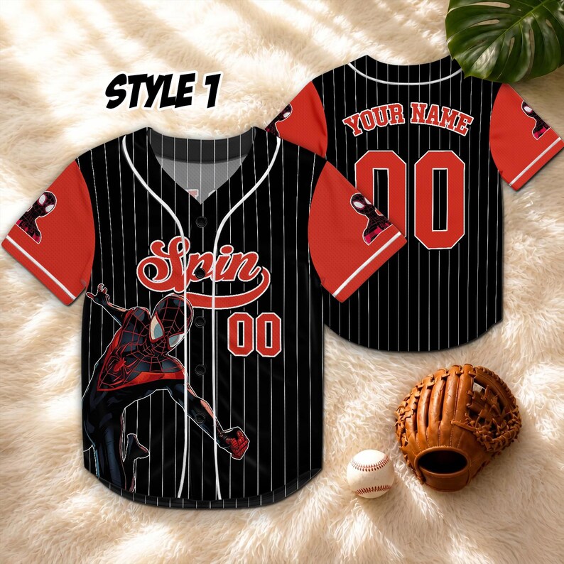May include: Black and red baseball jersey with white pinstripes, featuring a Spider-Man graphic and the word "Spin". The jersey has red sleeves and the number "00". A baseball glove and ball are also visible.