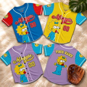 Könnte beinhalten: Vier Baseball-Trikots in Blau, Gelb und zwei Lilatönen mit einem Cartoon-Charakter-Design. Die Trikots zeigen den Namen "Maggie" und die Nummer "00". Auf einem Trikot steht "YOUR NAME" auf dem Rücken.