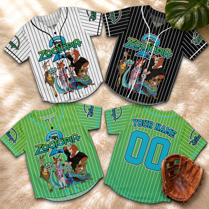 May include: Four baseball jerseys with the "Zootopia" logo and character graphics. The jerseys are white, black, and green with pinstripes. One green jersey has "YOUR NAME" and "00" on the back. A brown baseball glove is also visible.