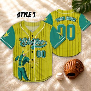 Puede incluir: Camiseta de b&eacute;isbol amarilla y verde con rayas verticales, con la palabra "Electro" y el n&uacute;mero "00". La camiseta tiene mangas verdes y un dise&ntilde;o de personaje de dibujos animados. Tambi&eacute;n se ven un guante y una pelota de b&eacute;isbol. El texto "STYLE 1" est&aacute; en la parte superior.