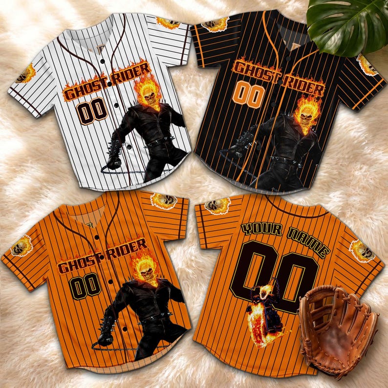 Op de afbeelding: Vier honkbalshirts met de Ghost Rider-afbeelding. De shirts zijn wit met zwarte krijtstrepen, zwart met oranje krijtstrepen en oranje met zwarte krijtstrepen. E&eacute;n shirt heeft een honkbalhandschoen.