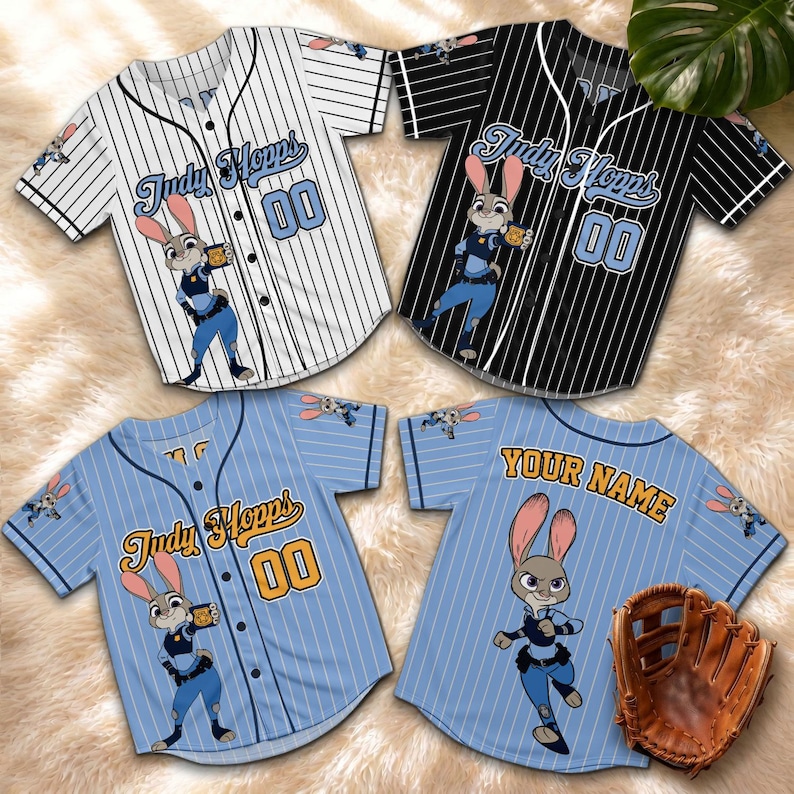 May include: Four baseball jerseys with a cartoon character design. Two jerseys are white with black pinstripes, and two are light blue with white pinstripes. Each jersey features the name "Judy Hopps" and the number "00". A baseball glove is also visible.