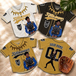 Könnte beinhalten: Vier kurzärmelige Baseballtrikots mit Knopfleiste, Nadelstreifen und dem Charakter Killmonger. Drei Trikots zeigen den Charakter auf der Vorderseite mit einer Panthermaske. Ein Trikot zeigt die Rückseite mit dem Text YOUR NAME und 00.