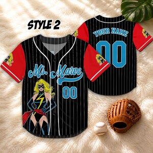 May include: Black and white pinstripe baseball jersey with red sleeves. Features the text "Ms. Marvel" and the number "00" in blue. Includes a cartoon graphic of Ms. Marvel. A baseball glove and ball are also visible.