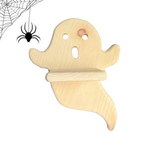 Pode incluir: Uma prateleira de parede de madeira de cor clara em forma de fantasma com dois recortes circulares para os olhos e um recorte oval para a boca. Uma pequena prateleira horizontal está fixada no centro da figura. Inclui um gráfico de aranha e teia.