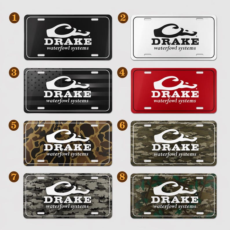 May include: A collection of license plates with the "DRAKE waterfowl systems" logo. The plates feature various designs, including solid black, white, red, camouflage, and a design with American flag stripes.