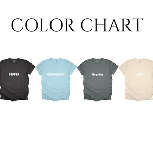 Pode incluir: Tabela de cores com quatro camisetas em cores diferentes: Pepper (preto), Chambray (azul claro), Granite (cinza) e Ivory (creme). Cada camisa tem o nome da cor impresso em branco.